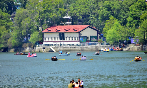 People in boats on a serene lake near a picturesque building. Enjoy a peaceful day surrounded by nature's beauty.